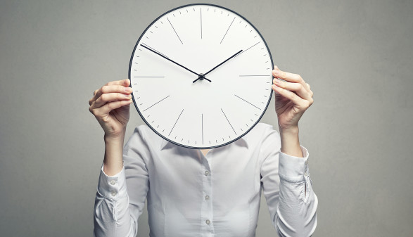 Frau hält Uhr vor Gesicht