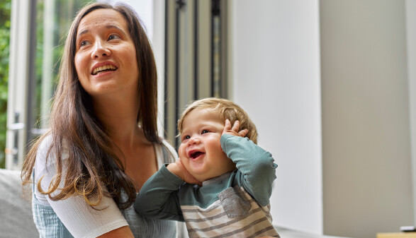 Mutter mit lachendem Baby am Schoß